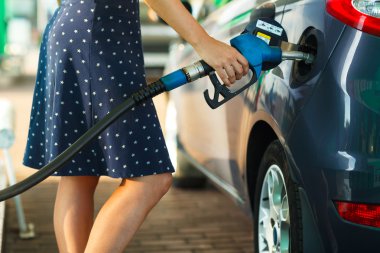 Bir benzin istasyonunda arabaya benzin kadın doldurur