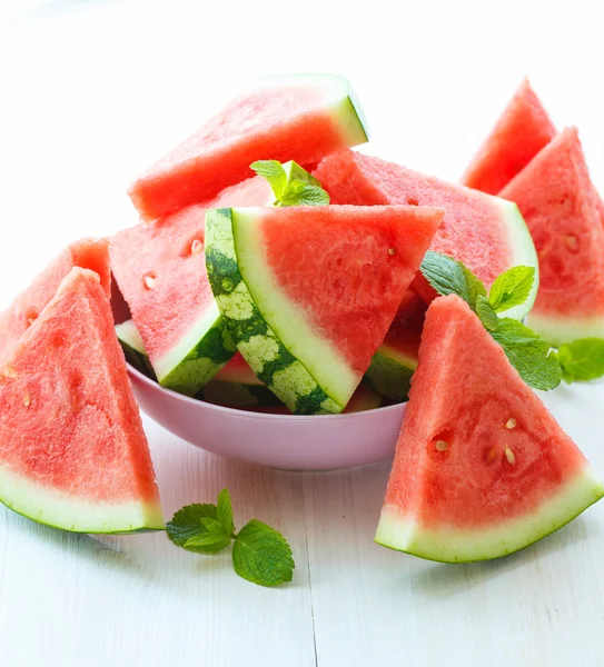Driehoekige segmenten van watermeloen met munt op witte houten backgr — Stockfoto