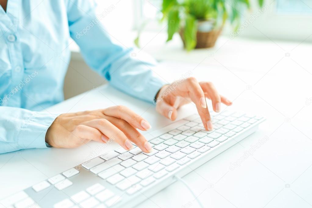 Woman office worker typing on the keyboard