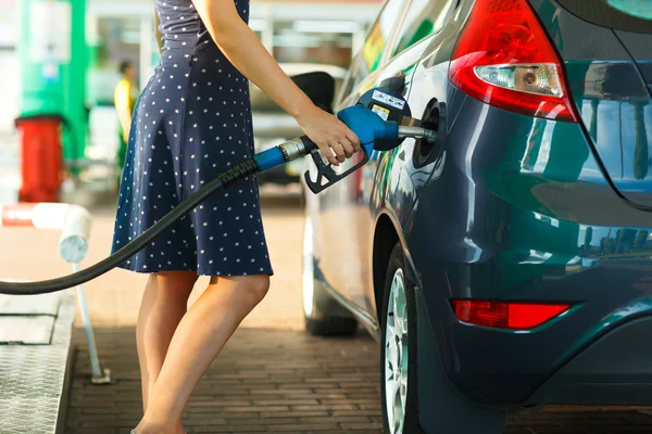 Женщина заправляет бензин в машину на заправке — стоковое фото