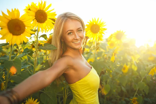 Wanita cantik dengan bunga matahari di matahari terbenam — Stok Foto