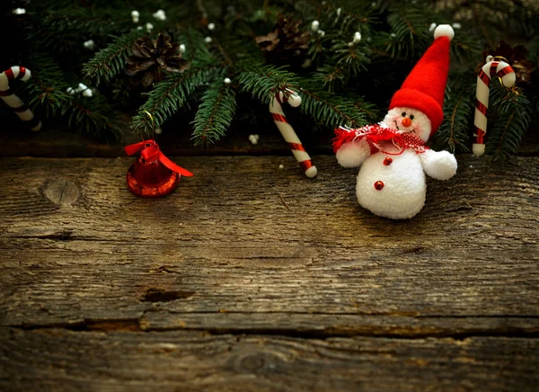 Christmas tree branches with christmas decorations and snowman o — Stock Photo, Image