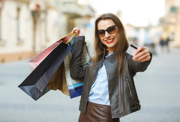 Mulher bonita com sacos de compras e cartão de crédito nas mãos — Fotografia de Stock