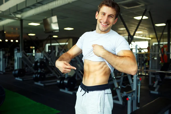 Αθλητικός άνδρας δείχνει κοιλιακούς μυς στο γυμναστήριο — Φωτογραφία Αρχείου