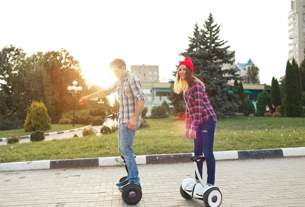 Um jovem casal equitação hoverboard - scooter elétrico, pessoal — Fotografia de Stock