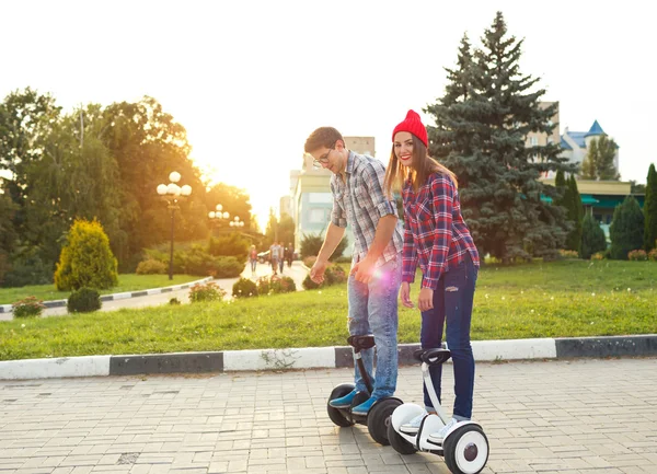 Una joven pareja montando hoverboard - scooter eléctrico, personal — Foto de Stock