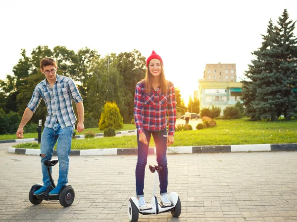 Um jovem casal equitação hoverboard - scooter elétrico, pessoal — Fotografia de Stock