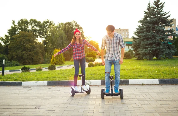 Una giovane coppia a cavallo hoverboard scooter elettrico, personale — Foto Stock