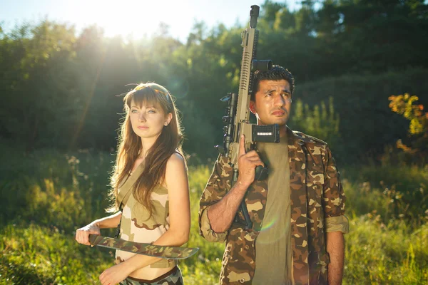 Menina branca e um homem árabe em camuflagem com uma arma no ha — Fotografia de Stock