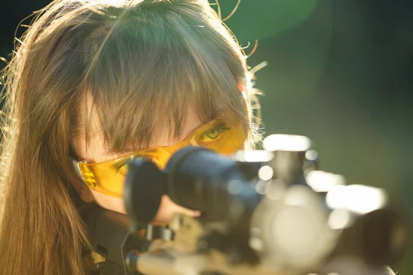 Flicka med en pistol för fälla skytte och skytte glasögon som syftar till — Stockfoto