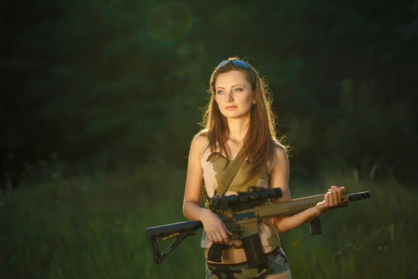 Giovane bella ragazza con un fucile in un esterno — Foto Stock