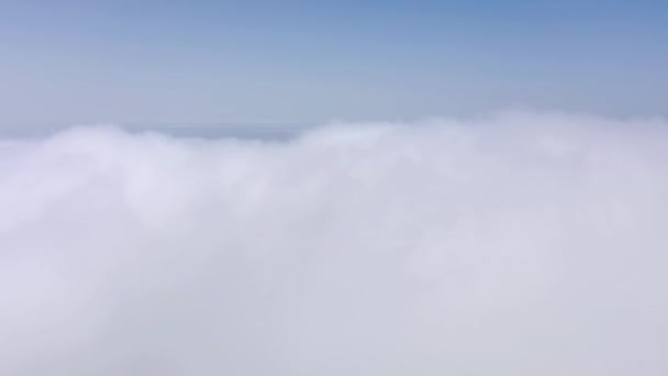 A drón magasan repül a kék égen a bolyhos felhők felett.. — Stock videók