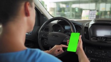 Kadın sürücü arabanın içinde akıllı telefon kullanıyormuş. Yeşil ekranlı Chromakey akıllı telefon. Otomatik navigasyon. İnternet bağımlılığı