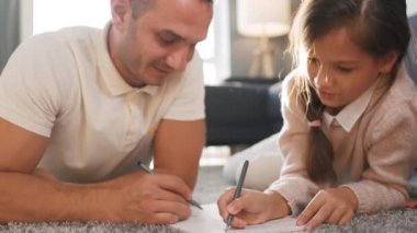 Baba ve kızı birlikte resim yapıp eğleniyorlar. Mutlu bir aile kavramı ve kaliteli bir eğlence zamanı.
