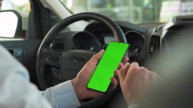 Sürücü arabanın içinde akıllı telefon kullanıyor. Yeşil ekranlı Chromakey akıllı telefon. Otomatik navigasyon. İnternet bağımlılığı