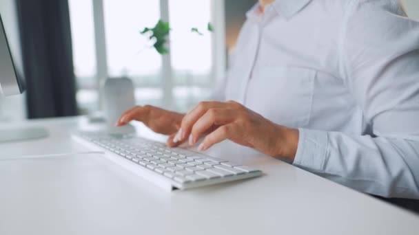Mujer con gafas escribiendo en un teclado de ordenador. Concepto de trabajo remoto. — Vídeos de Stock