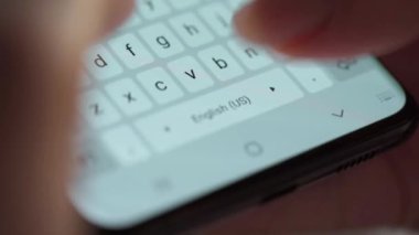 Akıllı telefondan yakın planda yazı yazan eller. Akşamları akıllı telefonları kullanarak.