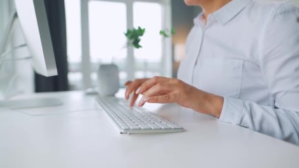 Kvinna med glasögon som skriver på ett datortangentbord. Begreppet distansarbete. — Stockvideo
