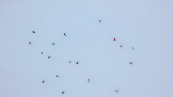 Blick von oben auf die Skipiste - viele Menschen geben sie auf Skiern und Snowboards weiter. — Stockvideo