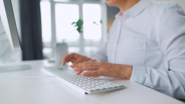 Жінка в окулярах друкує на клавіатурі комп'ютера. Концепція віддаленої роботи . — стокове відео