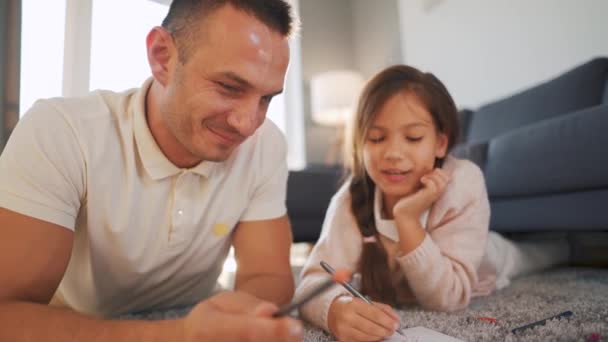 Vater und Tochter kommunizieren, haben Spaß und malen gemeinsam. Konzept einer glücklichen Familie und qualitativ hochwertiger Freizeit — Stockvideo