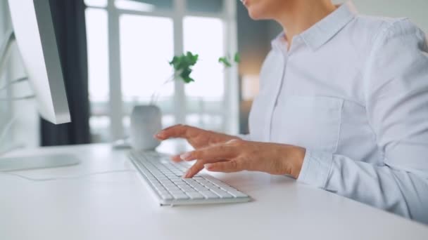 Mujer con gafas escribiendo en un teclado de ordenador. Concepto de trabajo remoto. — Vídeos de Stock