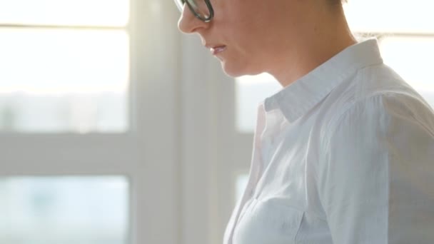 Mujer está sentada en el sofá en una habitación acogedora y trabajando en un ordenador portátil. Concepto de trabajo remoto. — Vídeos de Stock