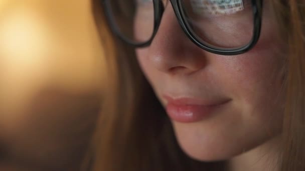 Mujer con gafas mirando en el monitor y navegando por Internet. La pantalla del monitor se refleja en las gafas. Trabaja de noche. Ministerio del Interior. Trabajo remoto — Vídeos de Stock