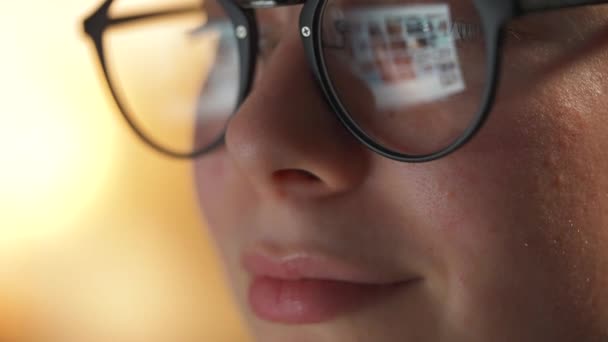 Mujer con gafas mirando en el monitor y navegando por Internet. La pantalla del monitor se refleja en las gafas. Trabaja de noche. Ministerio del Interior. Trabajo remoto — Vídeos de Stock