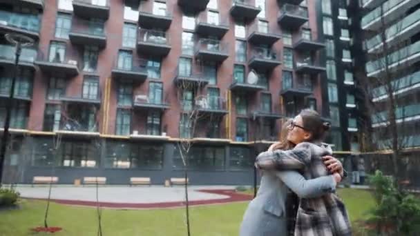 Două femei fericite se îmbrățișează atunci când se întâlnesc după o lungă separare . — Videoclip de stoc