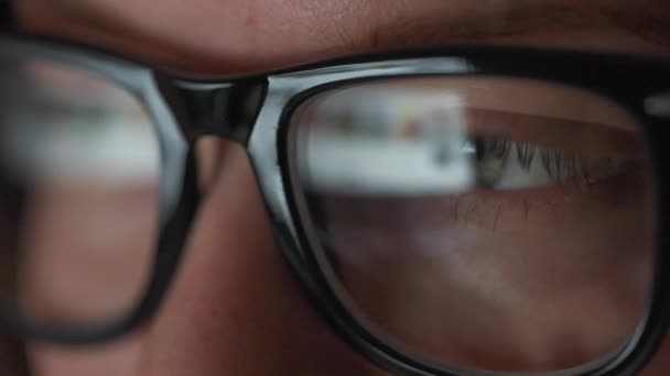 Mujer con gafas mirando en el monitor y navegando por Internet. La pantalla del monitor se refleja en las gafas. Trabaja de noche. Ministerio del Interior. Trabajo remoto — Vídeo de stock