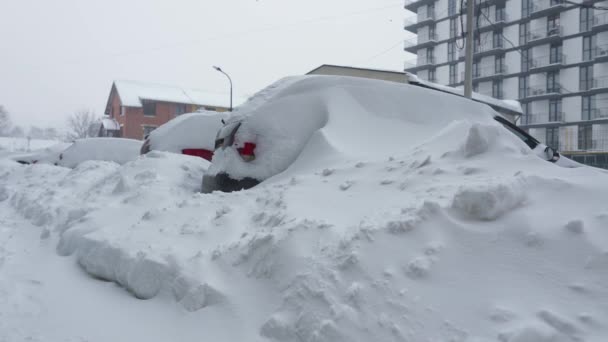 Auto coperte di neve dopo una bufera di neve. Edificio residenziale sullo sfondo. — Video Stock