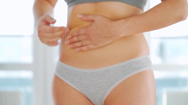 Wanita mengolesi perutnya dengan tanda peregangan gel dan melakukan pijat diri sendiri — Stok Video