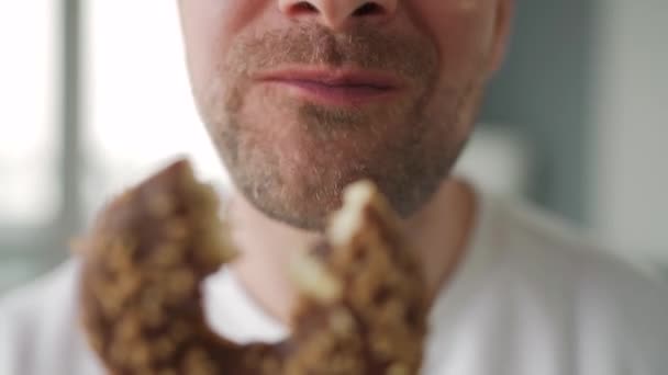 Hombre comiendo rosquilla de chocolate dulce. Primer plano — Vídeos de Stock