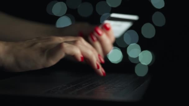 여자 손 이 밤에 온라인 구매를 위해 컴퓨터 키보드로 신용 카드 번호를 입력 한다. 온라인 결제 서비스. — 비디오