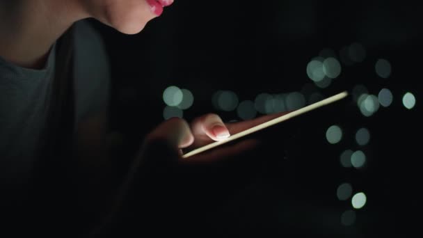 Mani femminili sta digitando su uno smartphone di notte. Luci sfocate sullo sfondo — Video Stock