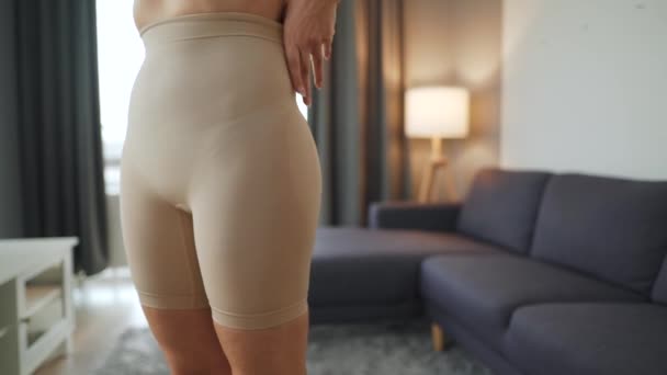 Woman puts on slimming underwear to improve body silhouette — Stock Video