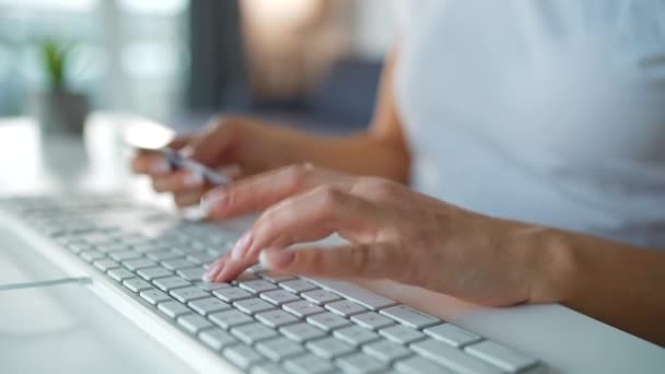 Vrouwelijke handen typen creditcardnummer op toetsenbord. Een vrouw die online koopt. Online betalingsdienst. — Stockvideo