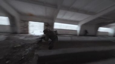Maskeli ve askeri üniformalı bir grup insan terk edilmiş bir binada hava yumuşaklığında. FPV İHA saldırısı