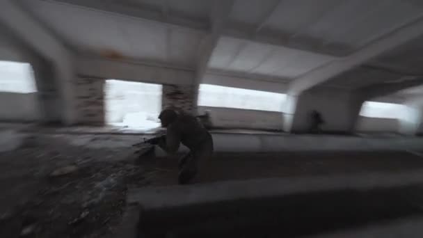 Group of people in masks and military uniforms are engaged in airsoft in an abandoned building. FPV drone shooting — Stock Video