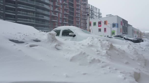 Samochody pokryte śniegiem po śnieżycy. Budynek mieszkalny w tle. — Wideo stockowe