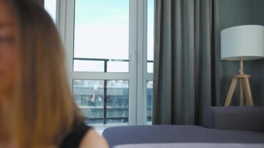 Siyah tulumlu beyaz kadın lotus pozisyonunda oturmuş meditasyon yapıyor, yoga yapıyor. Yavaş çekim