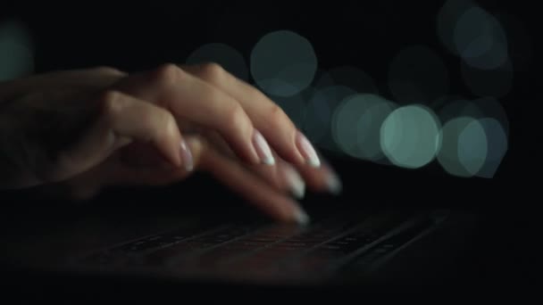 Les mains des femmes tapent sur un ordinateur portable la nuit. Lumières floues sur le fond — Video