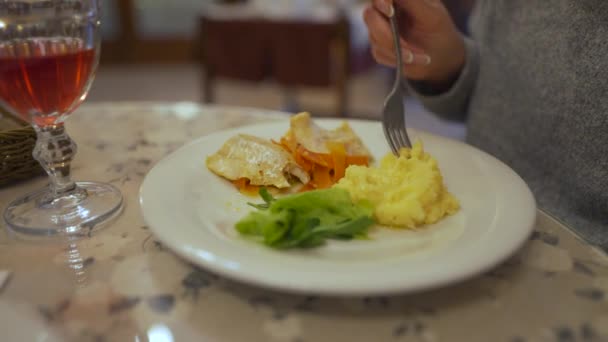 La mujer está almorzando en un café. Come pescado y puré de papas — Vídeo de stock