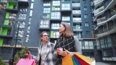 İki mutlu kadın başarılı bir alışverişin ardından alışveriş poşetleriyle ve kahve eşliğinde yürürler ve birbirleriyle ilgiyle konuşurlar. Yavaş çekim