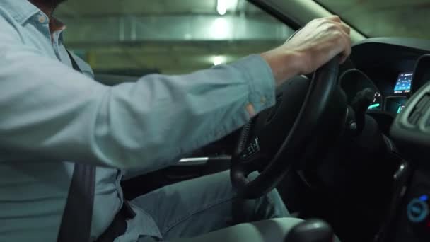Muž zaparkuje své auto pozpátku na podzemním parkovišti — Stock video