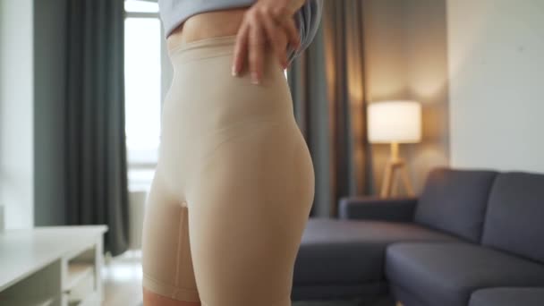 Frau zieht Schlankheitsunterwäsche an, um Körpersilhouette zu verbessern — Stockvideo