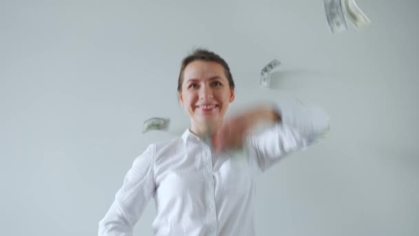 Happy formally dressed woman making money rain from dollar bills. Slow motion — Stock Video