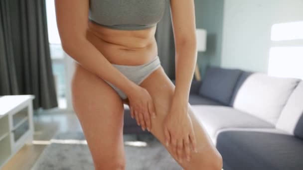 Frau schmiert sich Bein mit Anti-Cellulite-Creme und macht Selbstmassage — Stockvideo