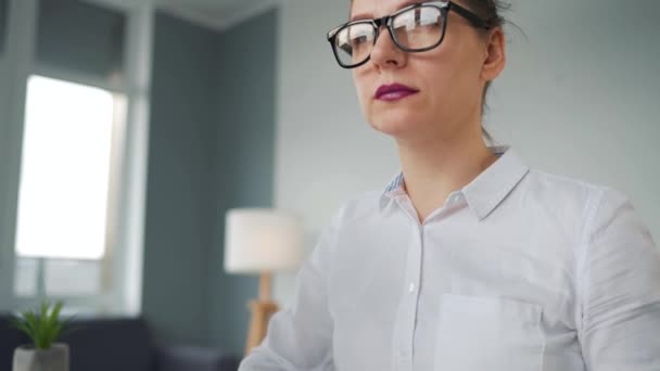 Женщина в очках печатает на клавиатуре компьютера. Концепция дистанционной работы. — стоковое видео